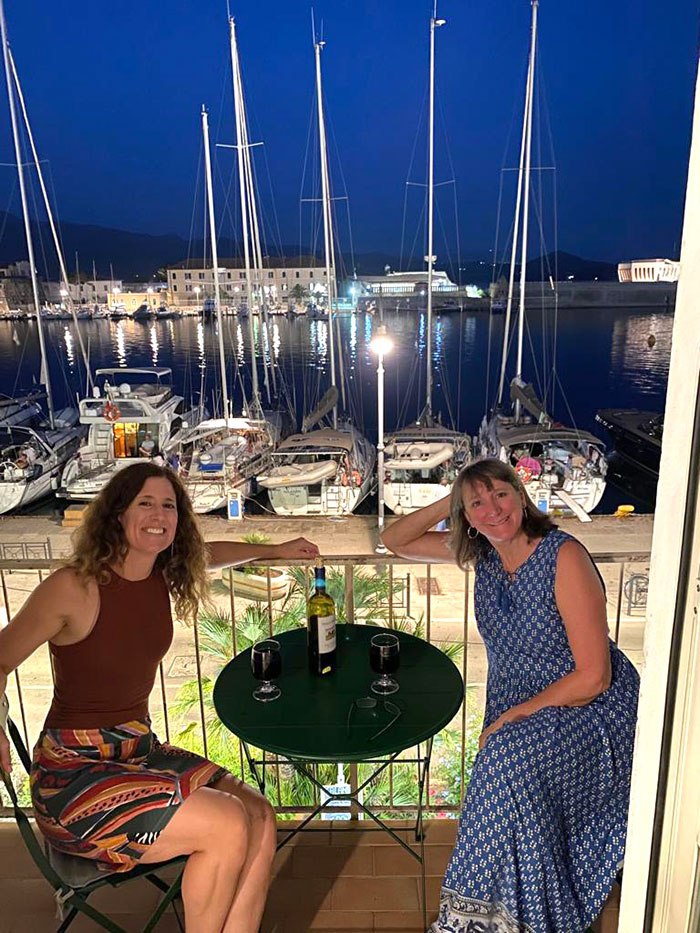 Danielle at dinner with a friend with boats in the background