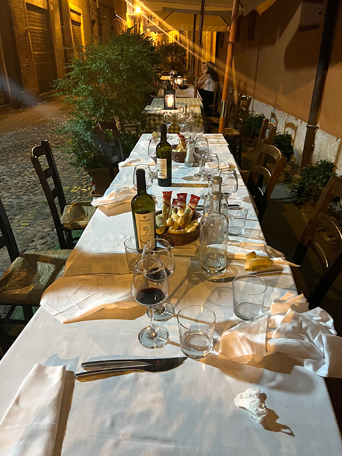 long table with white tablecloth and multiple settings